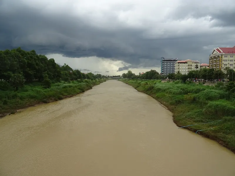 Sangker River in Battambang seen from a bridge, with a storm front approaching