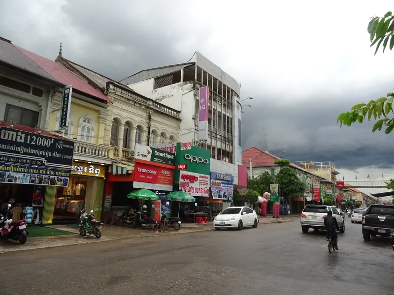 Road No 1 in Battambang with colonial-era shophouses and mobile phone shops