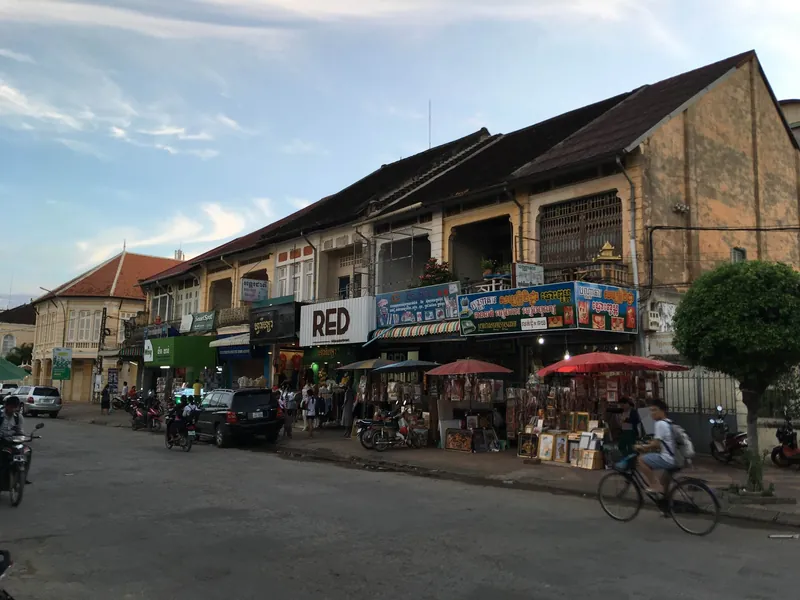 Picture-frame stalls in front of colonial shophouses on Road No 1 in Battambang in the evening
