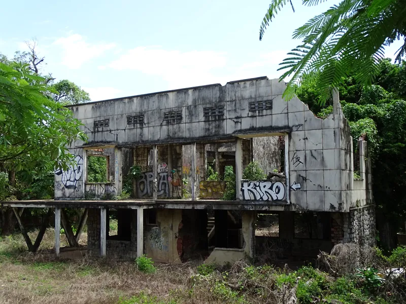 Ruine einer im Bürgerkrieg verlassenen Villa in Kep, mit Graffiti besprüht und überwuchert (zahlreiche Villen der 1960er Jahre stehen bis heute unsaniert leer)