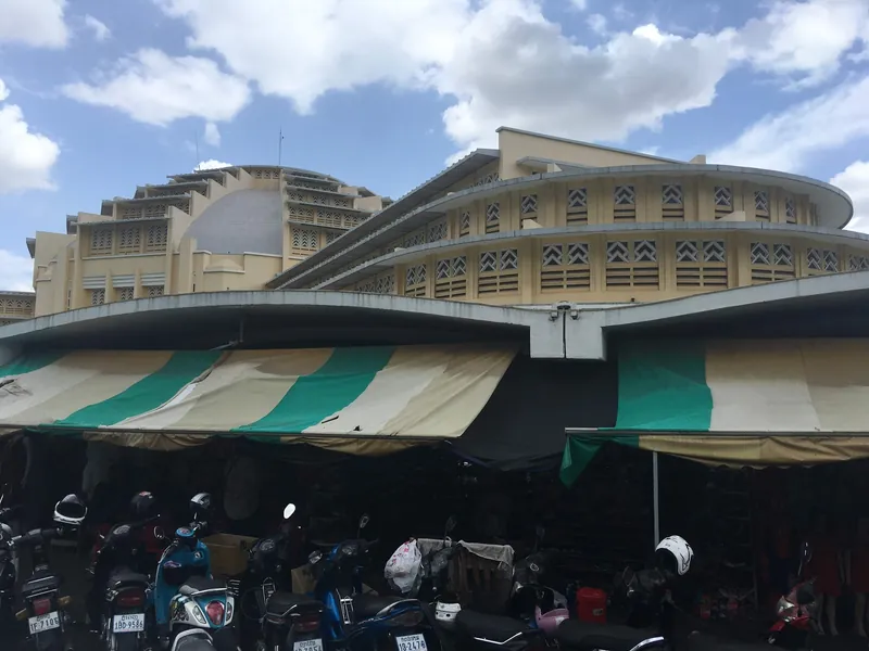 Art-déco-Kuppelbau des Zentralmarkts Phsar Thmei in Phnom Penh mit Außenständen und Motorrädern