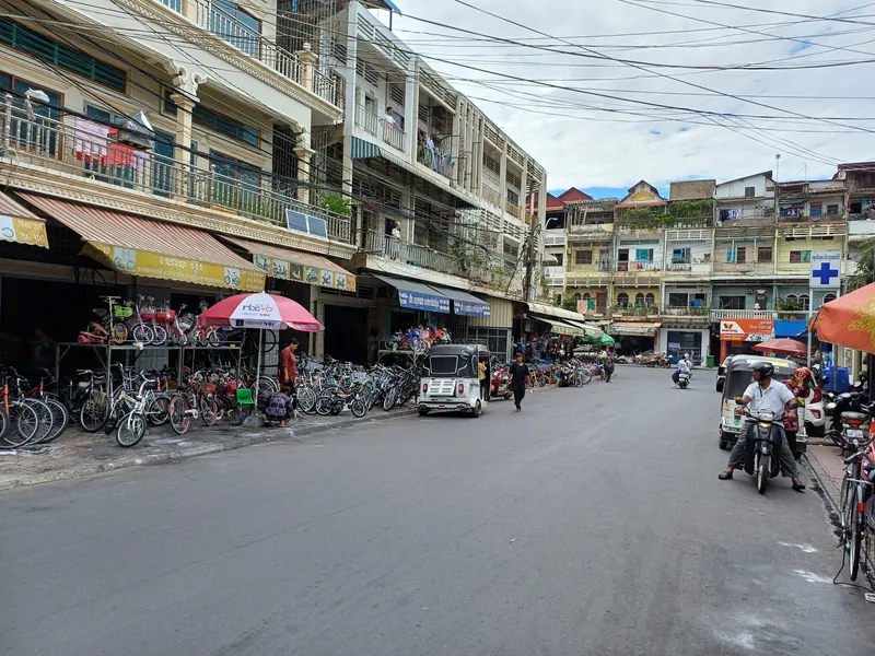 Geschäftsstraße in Phnom Penh mit Fahrradläden, Tuk-Tuks und Wohnhäusern aus der Kolonialzeit
