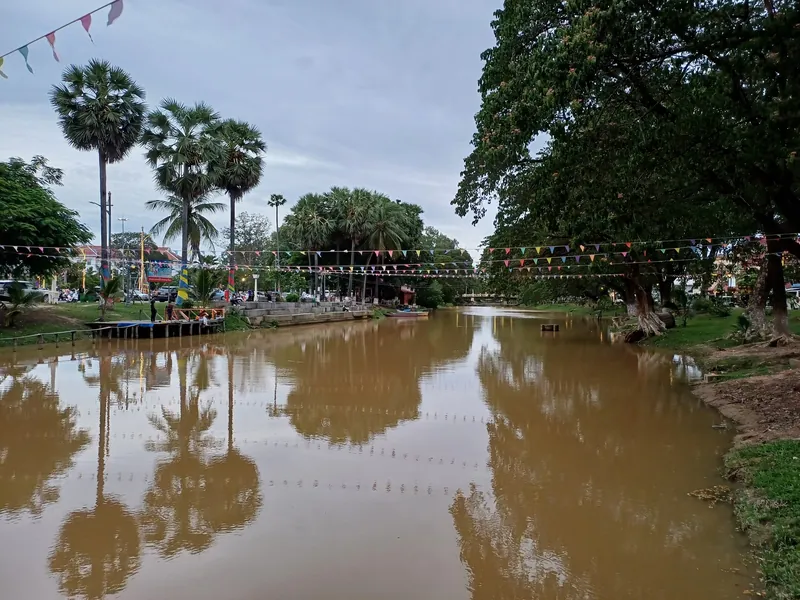 Siem Reap River im Stadtgebiet mit Zuckerpalmen und Wimpelketten