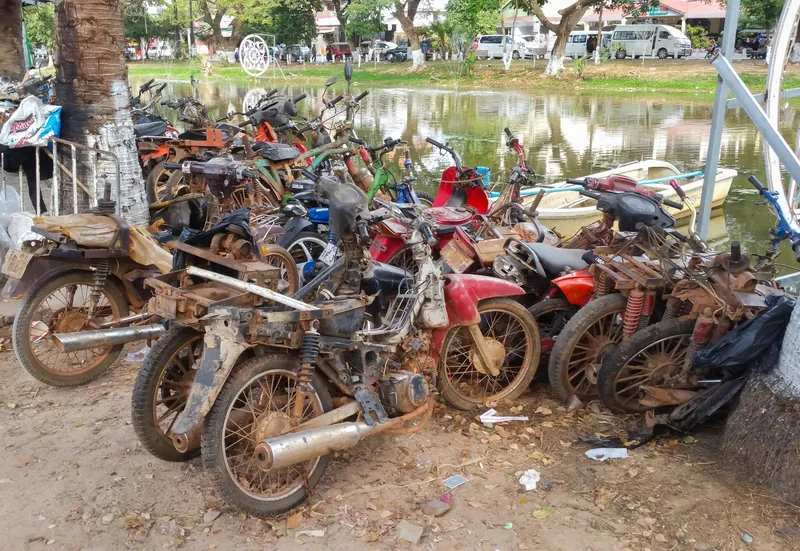 Rostende Motorräder auf dem Verwahrplatz der Polizei am Westufer des Siem Reap River (sichergestellte Fahrzeuge bleiben oft jahrelang im Freien stehen)