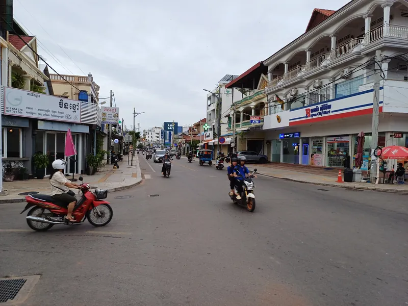 Main street in central Siem Reap with motorbike traffic, a minimart and ATMs