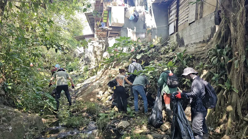 Frente Ecologista Atenas volunteers collecting rubbish from the Quebrada Cuajiniquil stream during their second clean-up. Houses stand right on the stream bed.