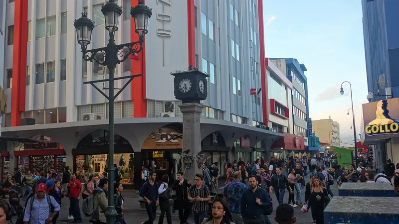Abendlicher Fußgängerstrom an der historischen Straßenuhr auf der Avenida Central in San José