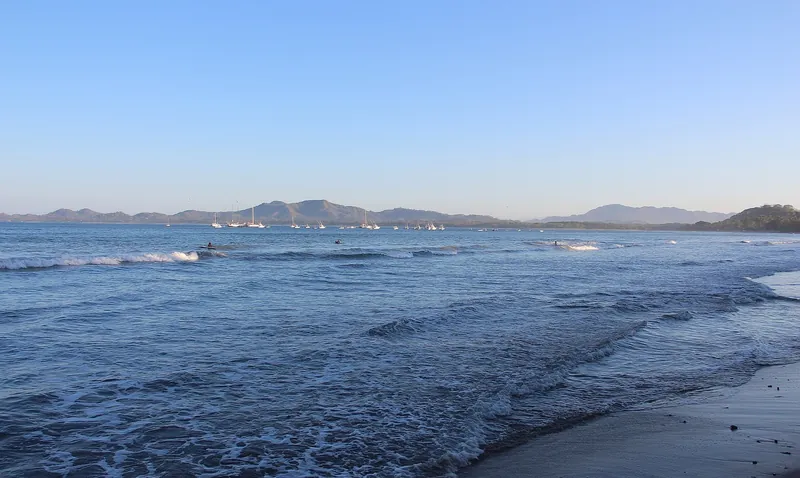 Bucht von Tamarindo mit ankernden Segelbooten und Surfern im Wasser