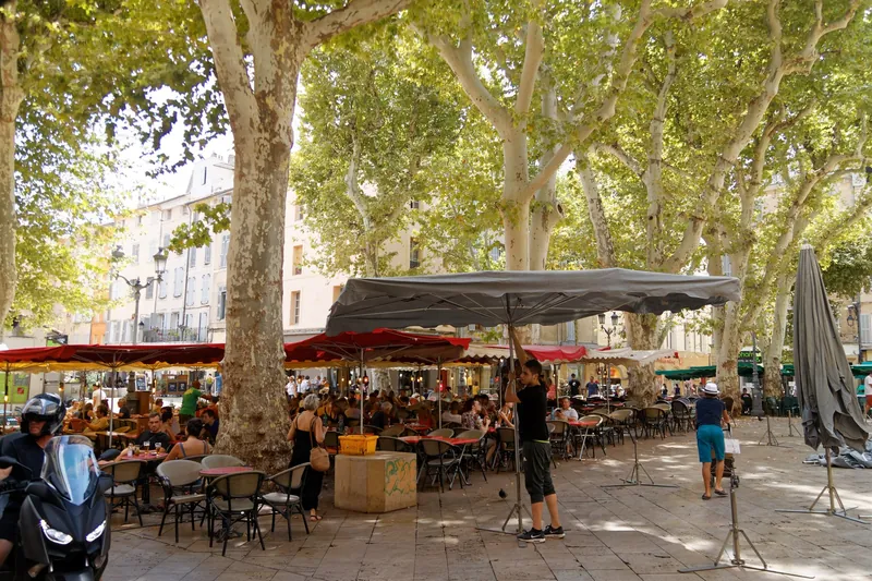 Place Richelme in Aix-en-Provence mit Caféterrassen unter Platanen und der Kornhalle von 1759