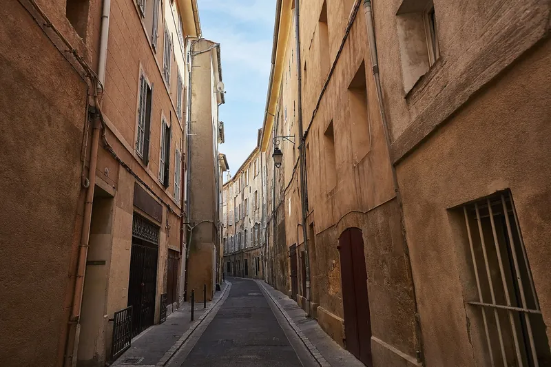 Schmale Altstadtgasse mit ockerfarbenen Häusern in Aix-en-Provence