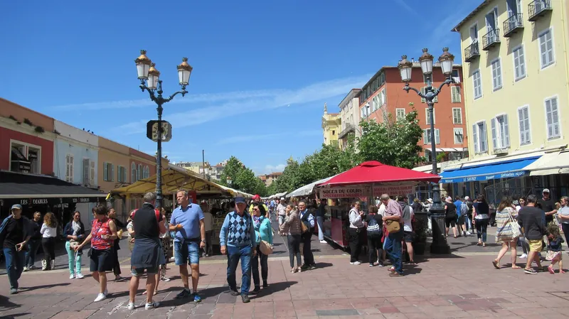 Cours Saleya in Nizza mit Marktständen und einem Stand für die Spezialitäten Socca und Pissaladière