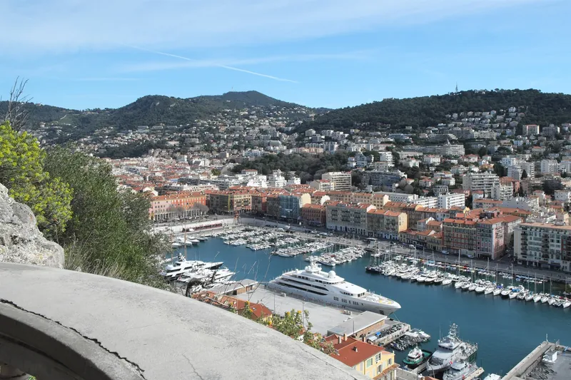 Blick vom Schlossberg auf den Hafen Port Lympia und die bewaldeten Hügel hinter Nizza