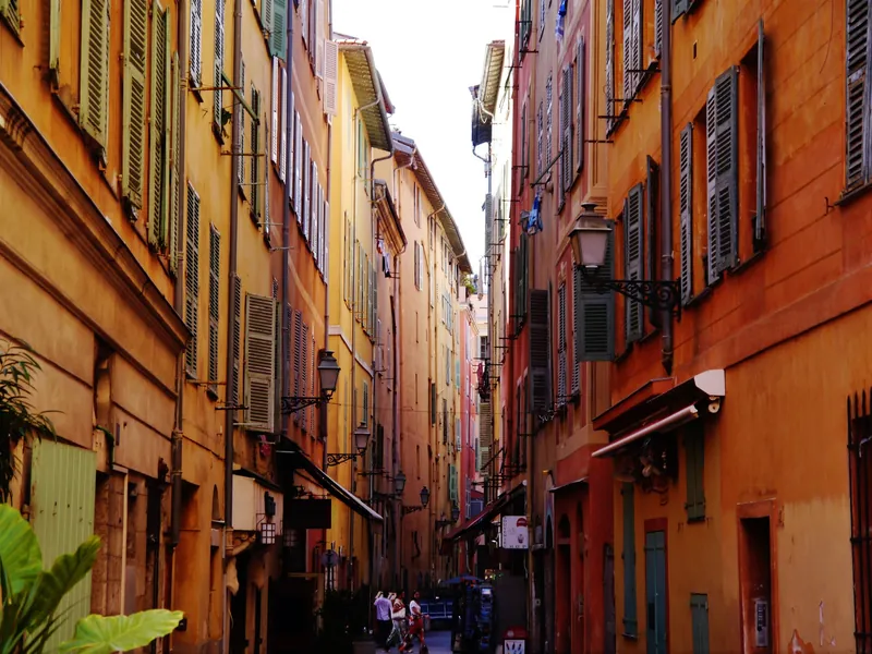 Narrow lane with ochre buildings and shutters in Vieux-Nice, the old town of Nice
