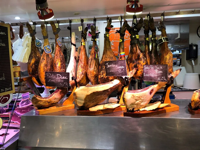 Schinkentheke mit Preisen in Euro pro Kilogramm in einer Markthalle in Toulouse