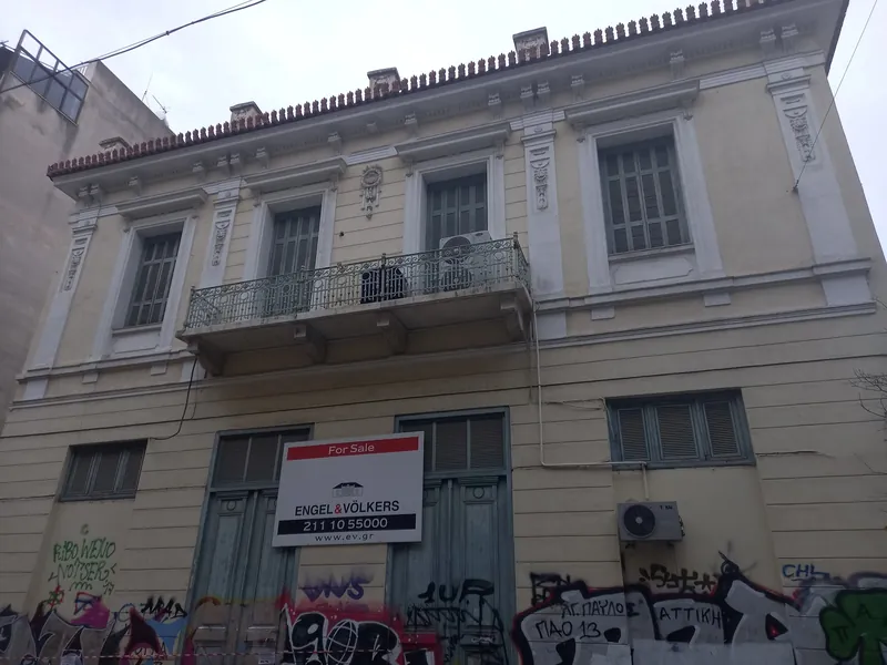 Neoklassizistisches Wohnhaus mit Verkaufsschild und Graffiti in der Chiou-Straße im Athener Stadtteil Metaxourgeio