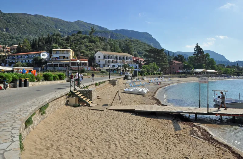 Main beach of Paleokastritsa on Corfu's west coast with loungers and hotels