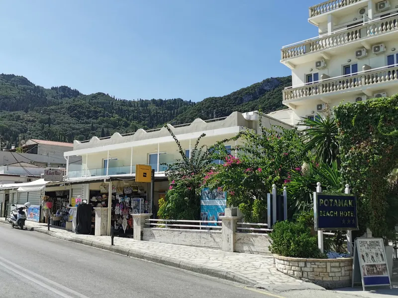 Hotel and souvenir shops on the main road through the coastal village of Benitses, Corfu