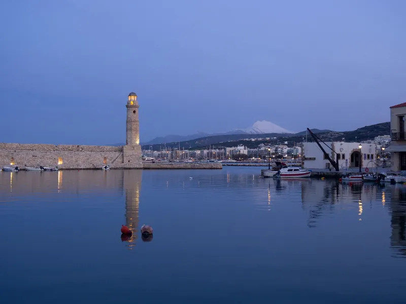 Alter Hafen von Rethymno auf Kreta mit Leuchtturm und dem schneebedeckten Psiloritis im Hintergrund