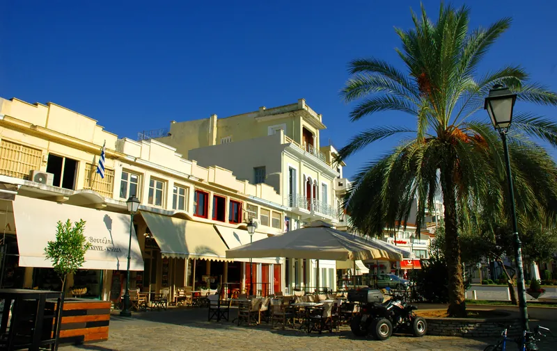 Square in Kalamata's old town with taverna terraces and a palm tree