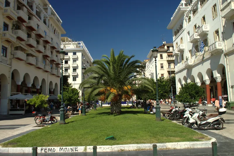 Aristotelous-Platz im Zentrum von Thessaloniki mit Palme, Arkaden und geparkten Rollern
