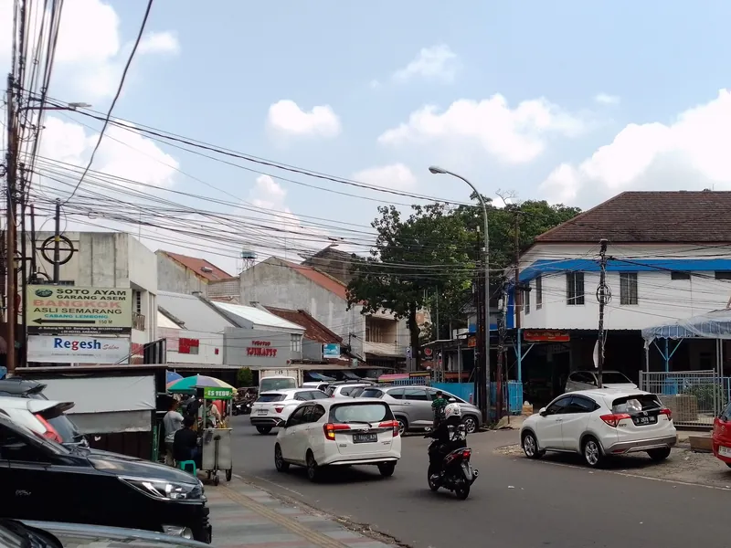 Straße vor dem Markt Cihapit in Bandung mit Warungs und geparkten Autos