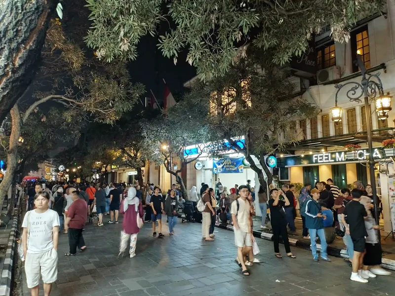 Pedestrians on car-free Jalan Braga in Bandung in the evening. The city has closed the street to traffic at weekends since 2024.