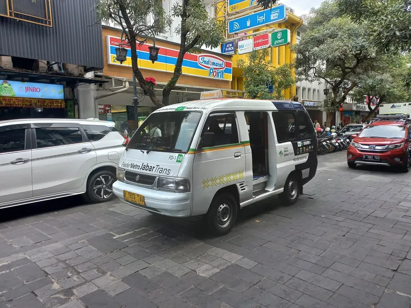 Zubringer-Kleinbus der Linie FD-1 von Metro Jabar Trans auf der Jalan Braga in Bandung