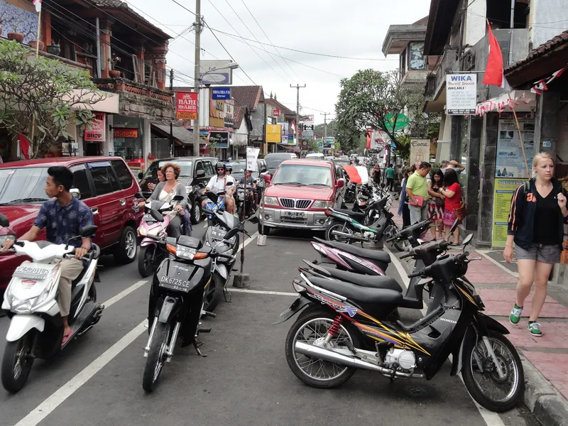 Dichter Roller- und Autoverkehr auf der Jalan Monkey Forest im Zentrum von Ubud (Staus treten hier ganzjährig tagsüber auf)