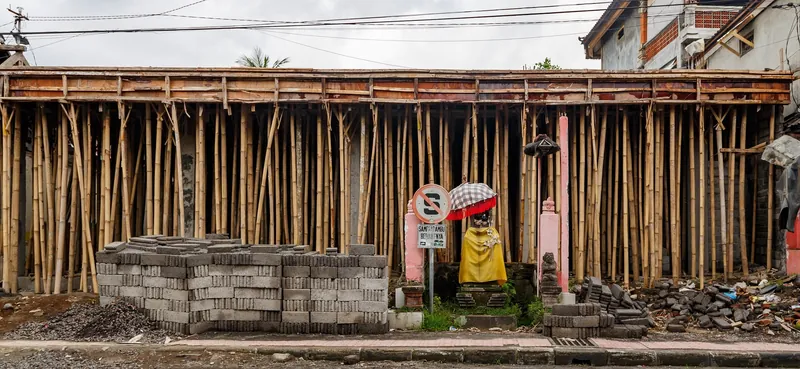 Baustelle mit Bambusgerüst und gestapelten Betonsteinen an der Hauptstraße von Ubud (Beispiel für die anhaltende Bautätigkeit im Ort)