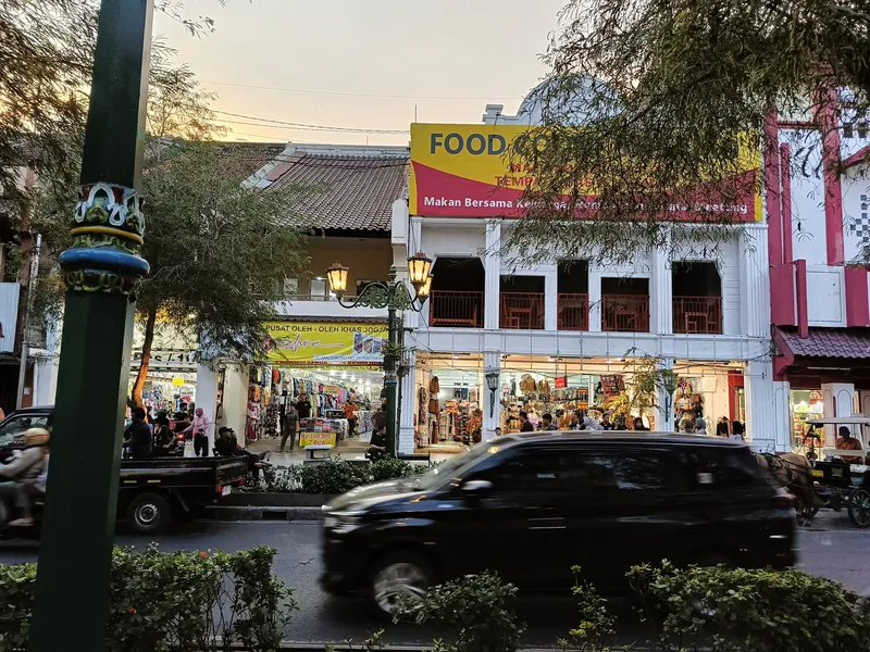Malioboro shopping street in Yogyakarta with shops and traffic at dusk