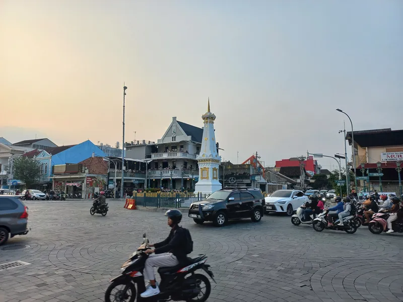 Tugu Pal Putih landmark at Yogyakarta's central crossroads with scooter traffic