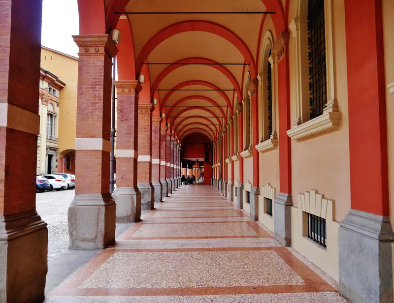 Rot gestrichener Arkadengang (Portico) in Bologna (die Portici von Bologna sind seit 2021 UNESCO-Welterbe)