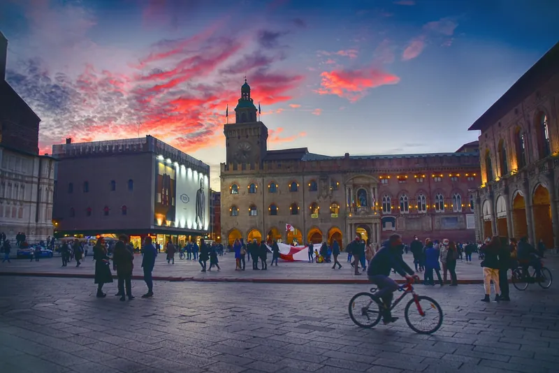 Piazza Maggiore in Bologna am Abend mit Passanten und Radfahrer