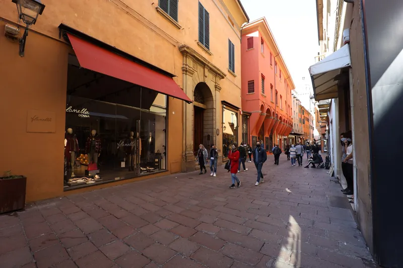 Arkadengang (Portico) der Via Massimo d'Azeglio in Bologna mit Geschäften und Passanten