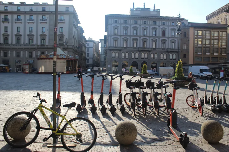 Abgestellte E-Scooter und Fahrräder an der Piazza della Repubblica in Florenz