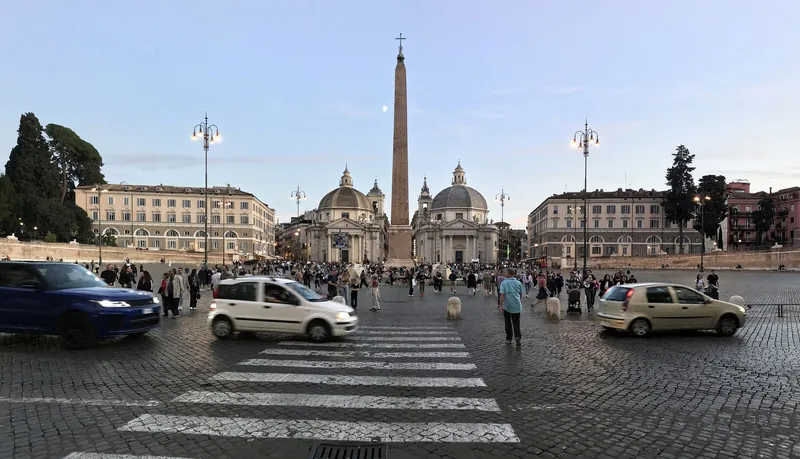 Piazza del Popolo in Rom mit Obelisk, Zwillingskirchen und Autoverkehr am Abend