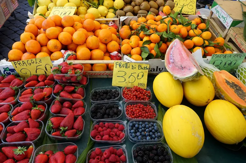 Obststand mit Preisschildern in Euro (Erdbeeren 2,50 EUR, Waldbeeren 3,50 EUR) auf dem Markt Campo de' Fiori in Rom