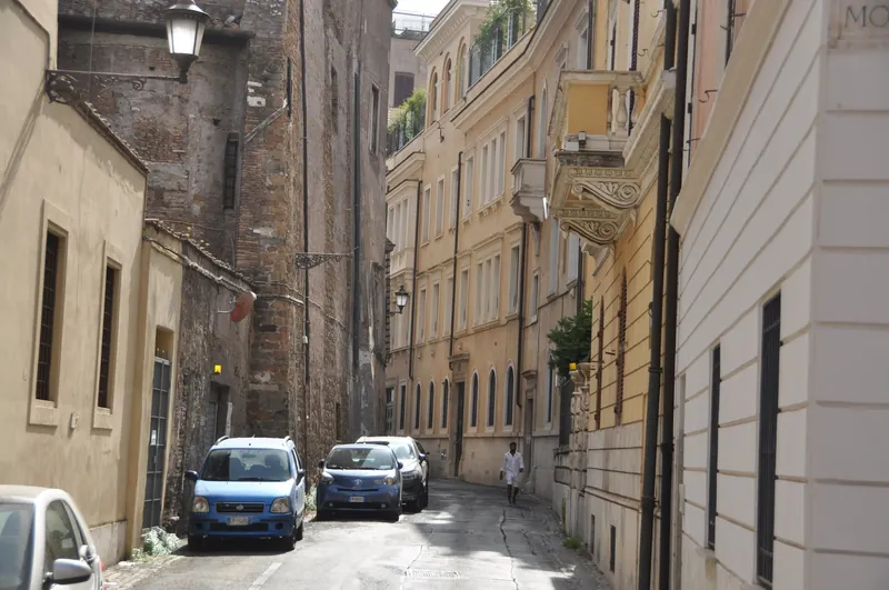 Ruhige Altstadtgasse in Rom mit parkenden Kleinwagen und Kopfsteinpflaster