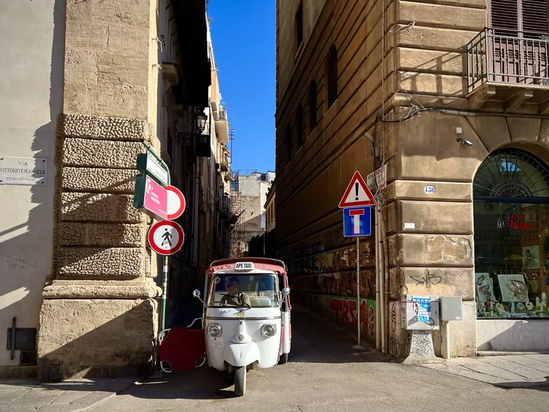 Narrow lane in Palermo's old town with a three-wheeled Ape van
