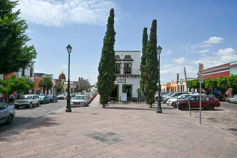 Square at the corner of Independencia and Venustiano Carranza in central Querétaro, with a restaurant and cypresses