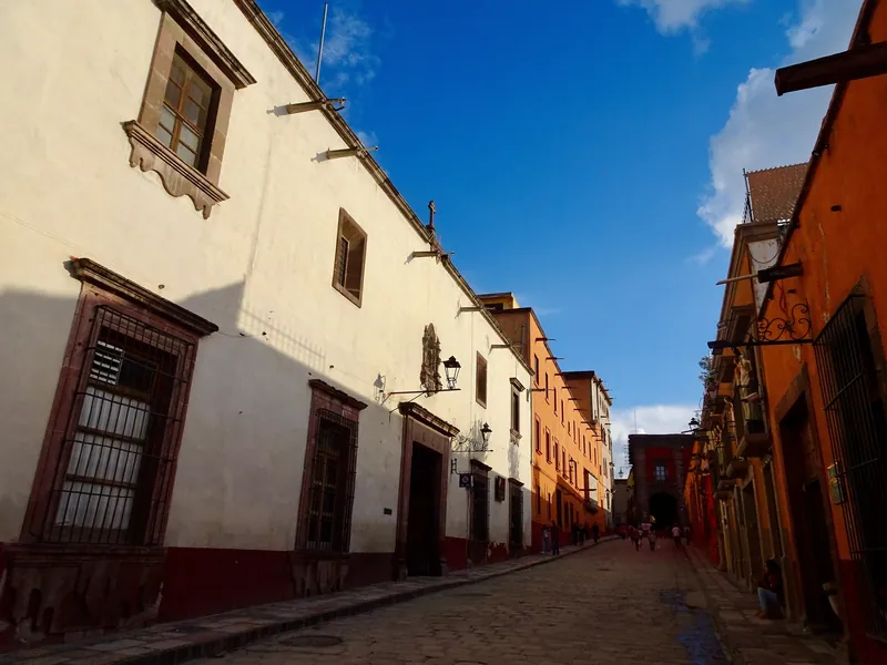 Kolonialstraße mit vergitterten Fenstern und Schmiedeeisenlaternen in San Miguel de Allende