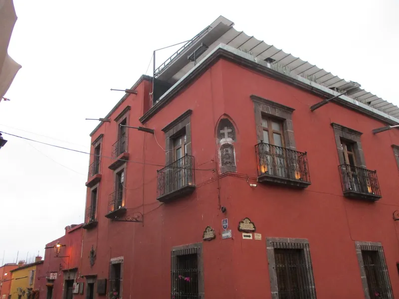 Rot gestrichenes Eckhaus mit Balkonen in der Altstadt von San Miguel de Allende