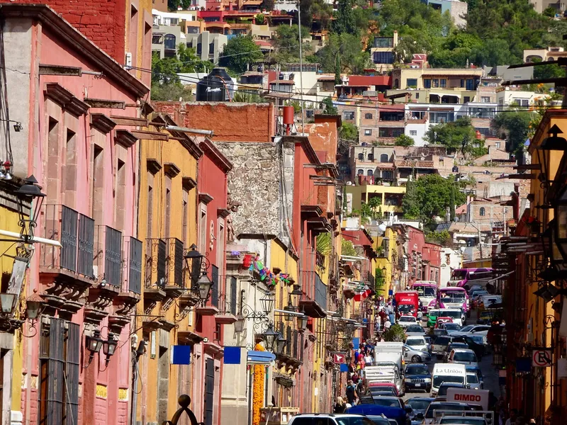 Stehende Autoschlange in einer engen Kopfsteinpflastergasse der Altstadt von San Miguel de Allende (der historische Kern ist für den heutigen Autoverkehr zu eng)