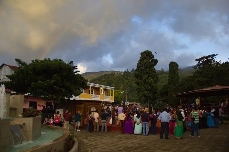 Parque Central in Boquete with visitors and a rainbow over the mountain valley
