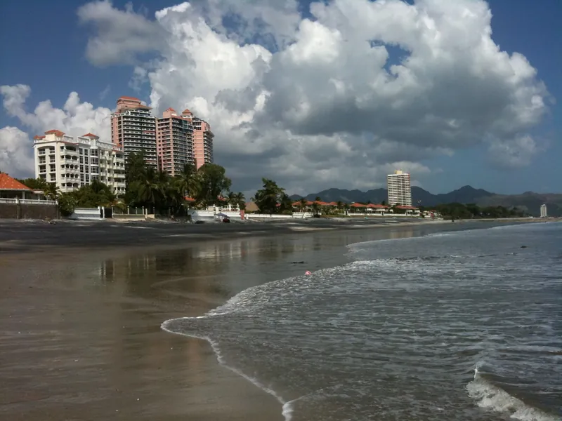 Dunkler Vulkansand und Wohnanlagen an der Playa Coronado