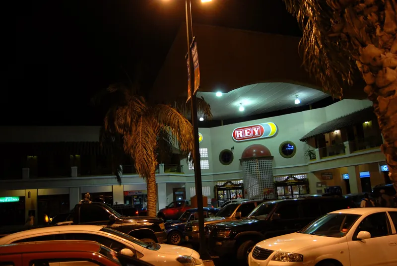 El Rey supermarket and row of shops at the entrance to Coronado at night