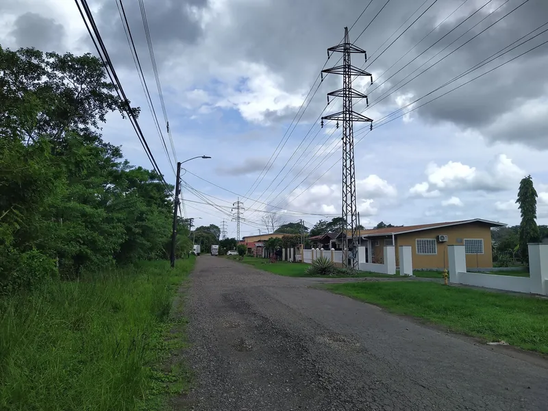 Unpaved residential street, Calle el Varital, in David with overhead power lines. Many side streets on the edge of the city are not paved.