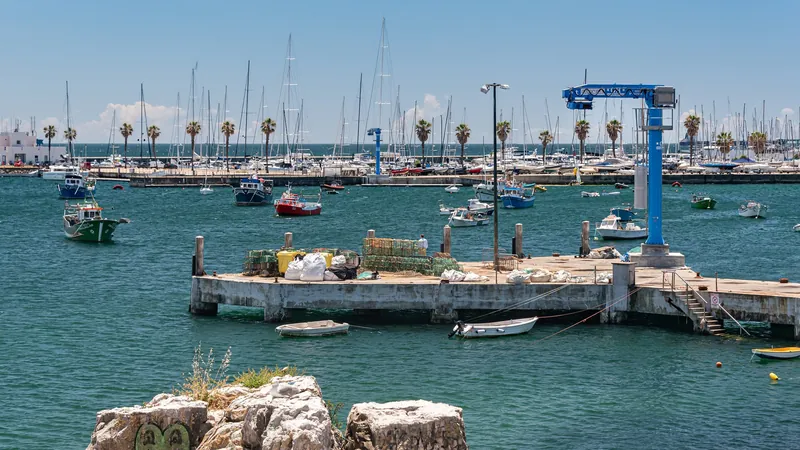 Fishing boats and pots on the pier at Praia da Ribeira in Cascais harbour