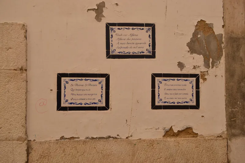 Azulejo-Tafeln mit Gedichtversen an einer Hauswand im Lissabonner Altstadtviertel Alfama