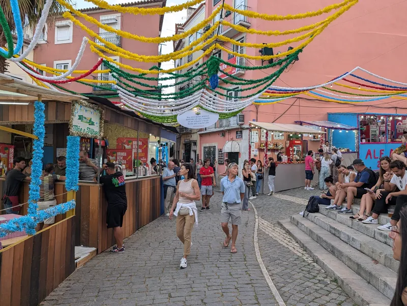 Mit Girlanden geschmückte Gasse und Getränkestände zum Volksfest Santos Populares in Lissabon